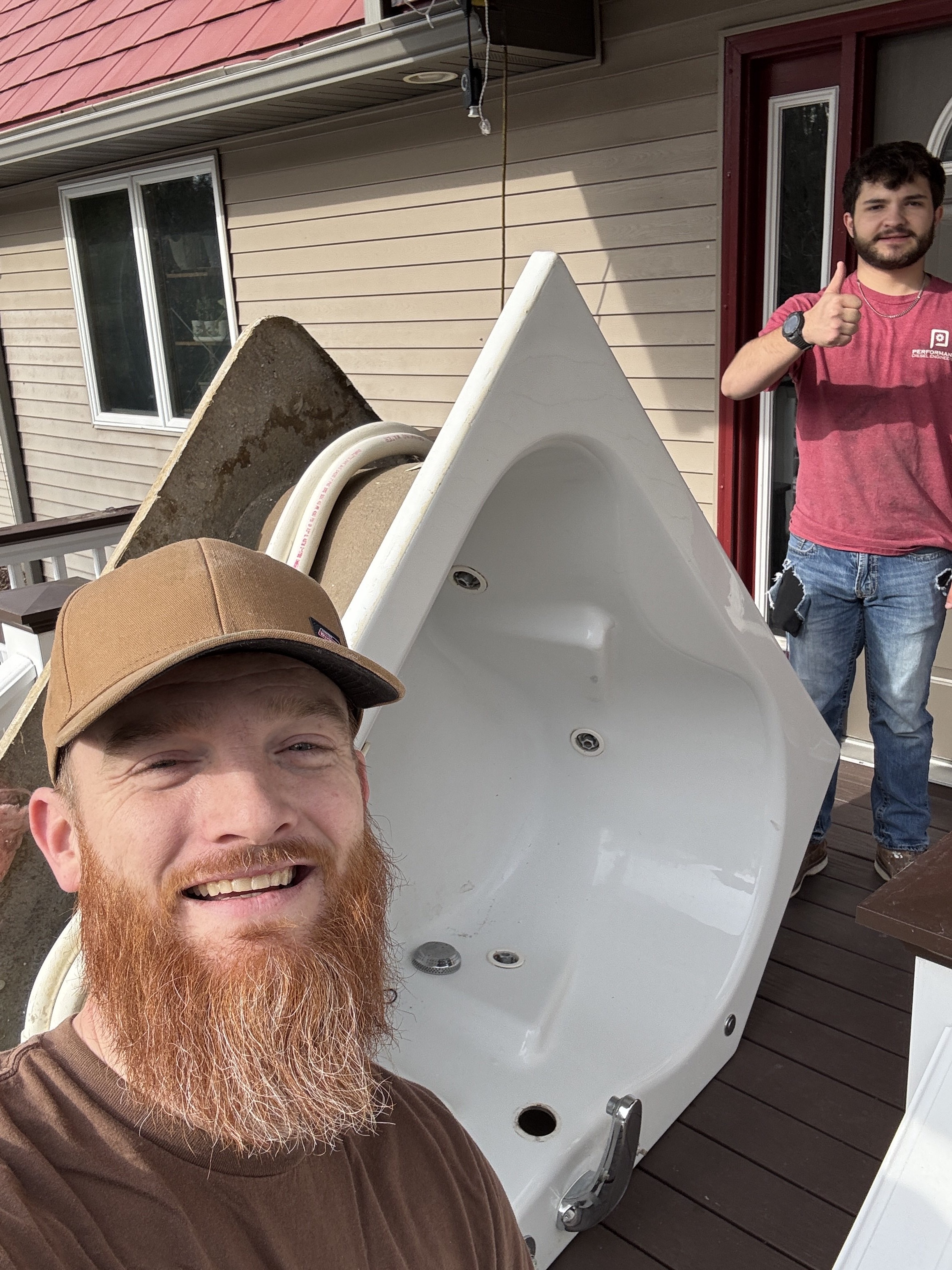 Team members collaborating on a bathroom remodeling project, delivering a bathtub